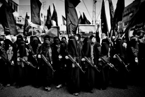 Una manifestazione jihadista a Gaza nel 2010: un insieme di persone di nero vestite, con lunghe tonache e veli a coprire quasi interamente il volto, sfilano imbracciando dei fucili