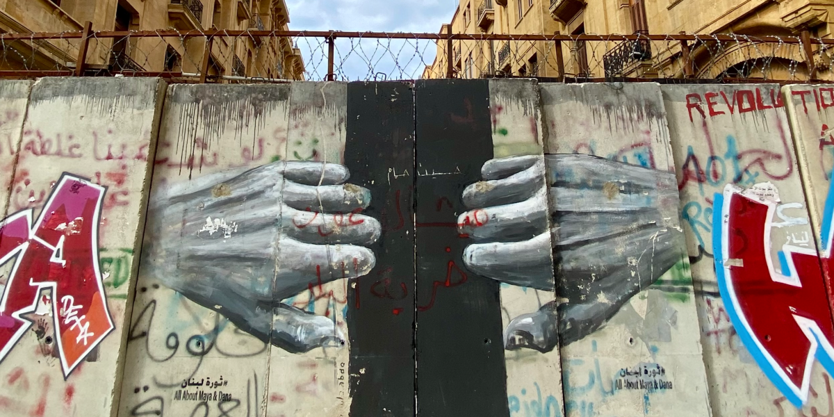 Un murale nel quartiere di Downtown a Beirut (Libano) sulle barricate poste durante la rivoluzione dell’ottobre 2019. Il murale raffigura due mani che tentano di aprire un portone.