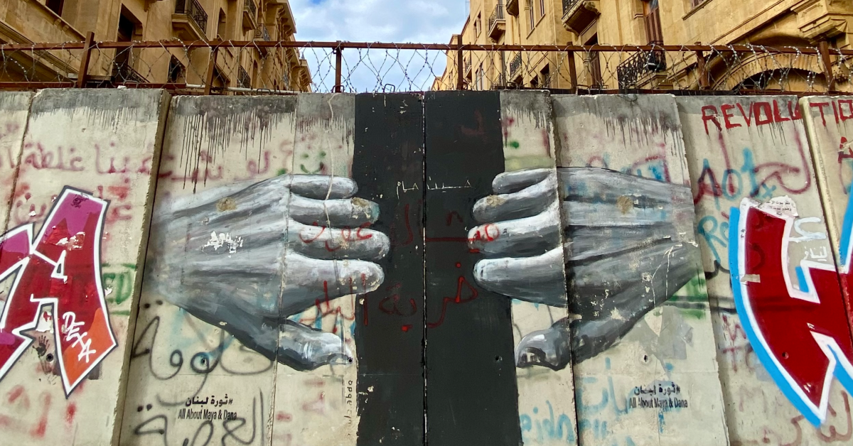 Un murale nel quartiere di Downtown a Beirut (Libano) sulle barricate poste durante la rivoluzione dell’ottobre 2019. Il murale raffigura due mani che tentano di aprire un portone.