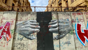 Un murale nel quartiere di Downtown a Beirut (Libano) sulle barricate poste durante la rivoluzione dell’ottobre 2019. Il murale raffigura due mani che tentano di aprire un portone.