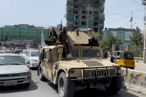 Alcuni soldati talebani, con in braccio dei mitra, a bordo di un blindato per le strade della capitale dell'Afghanistan Kabul
